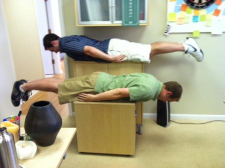 Jack and coworker plank in snazzy biz shorts
